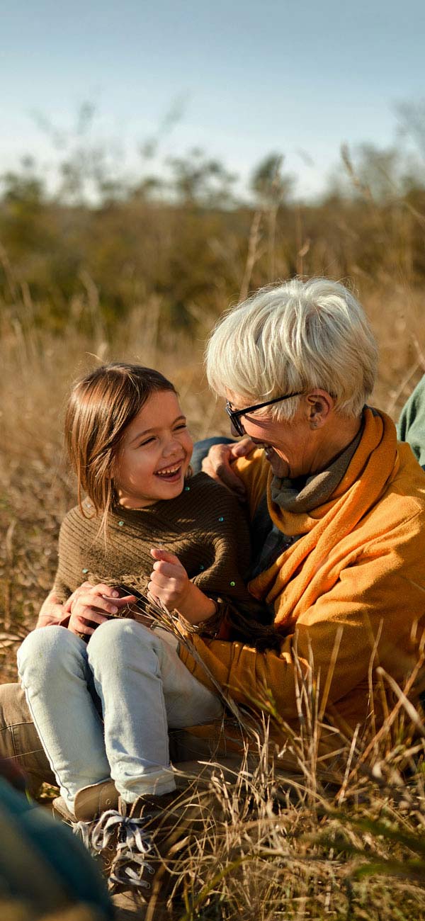 Famiglia sorridente seduta in un campo di grano