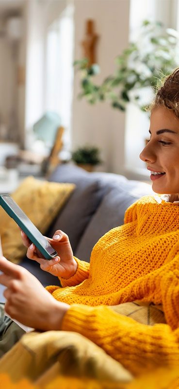 Ragazza con i ricci guarda qualcosa sul proprio smartphone con aria di approvazione