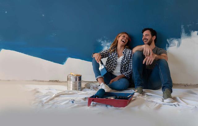 Giovane coppia scherza mentre dipinge una parete