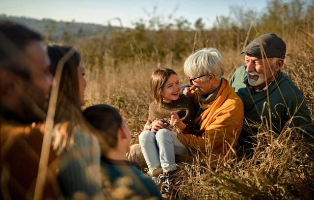 Famiglia sorridente seduta in un campo di grano