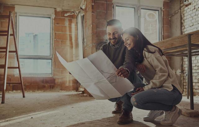 Coppia esamina soddisfatta il progetto in una casa in costruzione