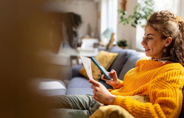 Ragazza con i ricci guarda qualcosa sul proprio smartphone con aria di approvazione